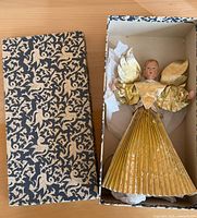 angel tree topper inside patterned box with lid removed