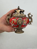 Full view of censer showing red porcelain body, metal lid, dragon handles
