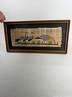 Frontal view of framed papyrus painting showing full artwork and frame
