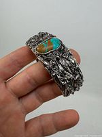 Front view showing turquoise cabochon and ornate design