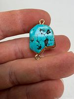 Front view of turquoise pendant showing color, veining and top loop