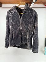 Front view of grey fleece jacket on hanger, full zip and stand collar visible