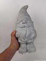 Front view of grey concrete gnome held in hand