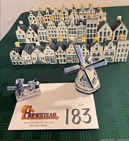 Front view of collection of miniature houses arranged in rows with two windmills in foreground