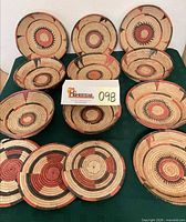 Group of woven reed baskets, bowls and trivets displayed on table