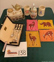 All items laid out showing coffee set, steins, bar set, cloth art