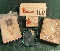 Lot overview showing all three boxed necklaces and amber earrings