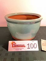 overall view of green glazed ceramic jar with lot card