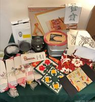 Overview of all items on table including bed tray box, appliance box, baking sheets, towels, pot holders
