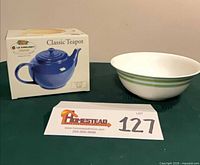 Boxed Le Creuset blue classic teapot beside Kate Spade Lenox green striped bowl