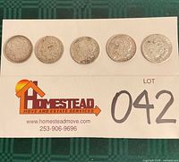All five Morgan silver dollars laid out obverse side