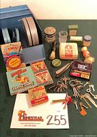 Overall lot view showing film case, reels, film boxes, grooming items and keys