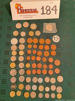 Overview of 76 mixed coins laid out on green cloth