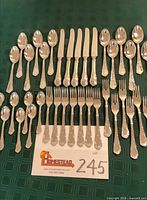 Overview of all 39 flatware pieces arranged on table