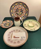 All five pottery pieces grouped: two chargers, small platter, pitcher, chip-and-dip platter