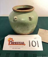 front view of green glazed porcelain jar with lot card