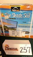 Front of ShelterLogic Sun Shade Sail box showing product name and size
