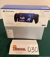 Front view of boxed PlayStation Portal atop PS5 box