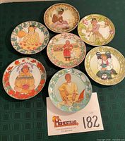 Seven decorative plates laid out on table