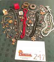 Full lot overview showing variety of necklaces, earrings, brooches, bracelets, charms and approx. quantity