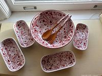 Full set displayed: large bowl center, four rectangular dishes, two wooden servers