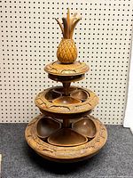 Full view of three-tier carved wood snack server with pineapple finial