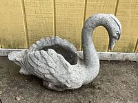 Side view of concrete swan planter showing overall form and feather details