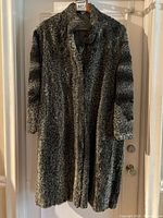 Front view of grey Persian lamb fur coat on hanger