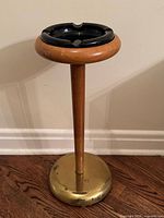 Full view of floor-standing ashtray showing wood stem, brass base, black glass top