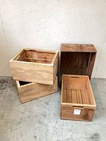 Four assorted wooden crates arranged upright and on side showing size variations and finishes