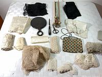 Overview of lace pieces, hat pins, mirror, file, scissors and purse