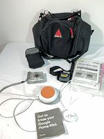 Overview of lot with camera, bags, Google Home Mini, headlamp and manuals