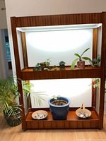 Shelving unit lit, showing grow lights, casters, and included potted plants