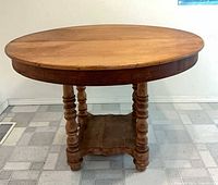 Full view of round dining table showing top, legs, shelf