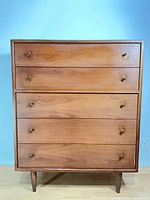 Front view showing five drawers, knobs, legs