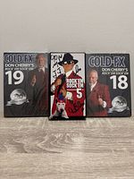 Front view of three media cases: sealed DVDs volumes 18 and 19 and signed VHS volume 5