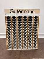 Frontal view of Gutermann spool holder showing full slot array and branded header