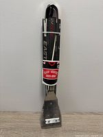 Full view of bundled BBQ utensil set showing hockey stick handles and packaging