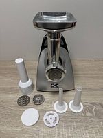 Front view of Kalorik meat grinder with all accessories laid out