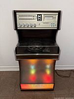 Full view of stereo console showing control panel, turntable bay, illuminated speaker section