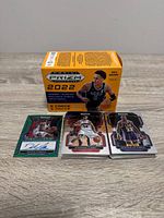 Front view showing sealed blaster box and three featured Prizm cards (green autograph relic, Stephen Curry silver, Shaquille O'Neal purple)