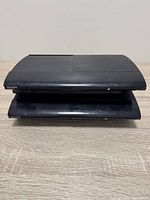 Two stacked Sony PS3 Super Slim consoles front view