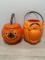 Front view of both pumpkin pails showing faces and handles