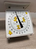 Dial close-up showing Sunbeam branding, 0-24 lb scale and animal graphics