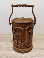 Front view of carved wooden wine bottle cooler with lid and handle