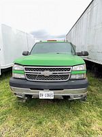 Front view of bright green Chevrolet Silverado 2500HD showing grille, headlights, bumper, license plate BY-13665, and amber roof lights