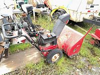 Red walk-behind snowblower side view showing engine, chute, tires, rust