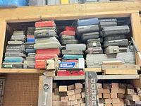 Full shelf of stacked plastic tool cases in assorted colours