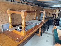 Upside-down wood dining table, additional table and chairs along trailer wall