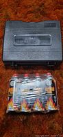 Plastic carrying case marked PORTABLE GAS STOVE with shrink-wrapped fuel pack beneath